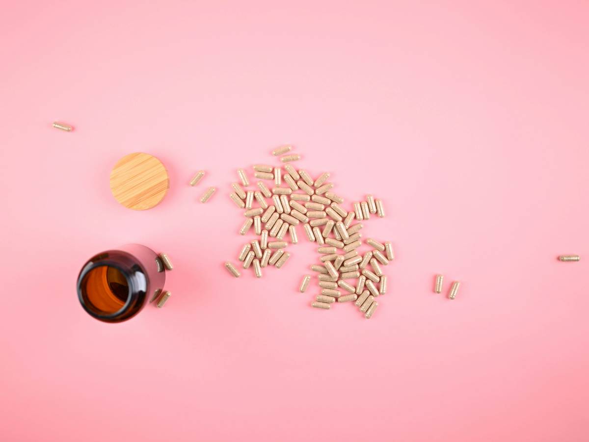 Woman taking supplements for after menopause with morning tea and journal