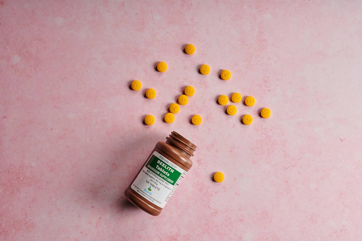 what supplements help with menopause: woman reviewing supplement bottles with notebook on kitchen table