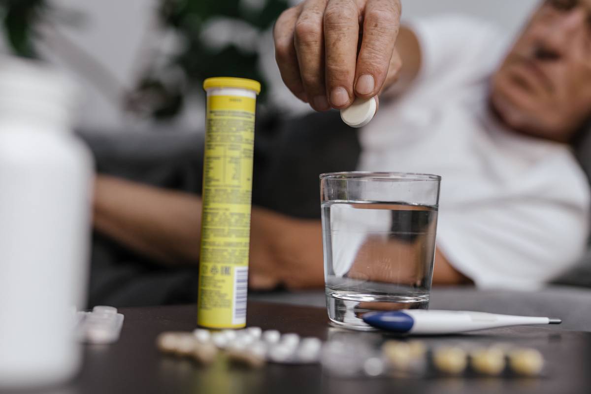 supplements to help sleep during menopause on a bedside table next to a journal and glass of water